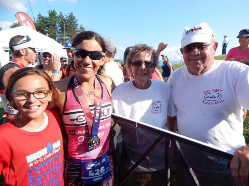 Amy Farrell flanked by her 11 year old daughter Ruby, left, and her parents, right, after becoming the 2015 Lake Placid Ironman Women's Overall Champion