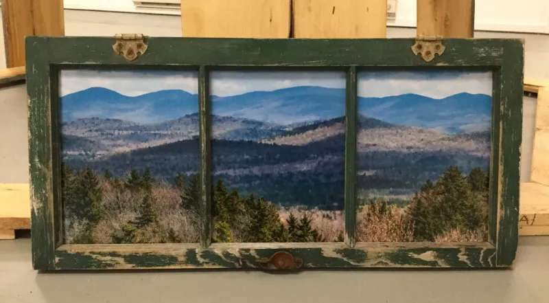 This repurposed window frame creates a perfect setting for the landscape view the artist has created.