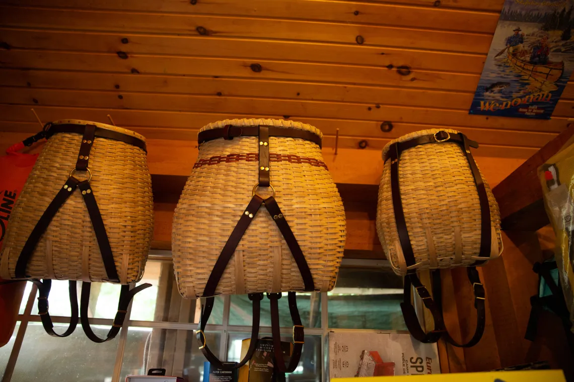 A row of three Adirondack packbaskets hang from a beam.