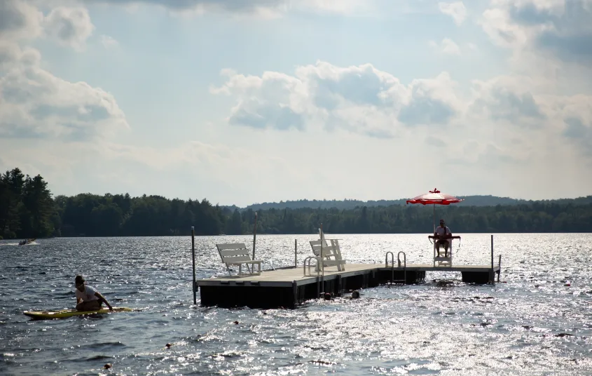 A dock with chairs on it&#44; floating in the water