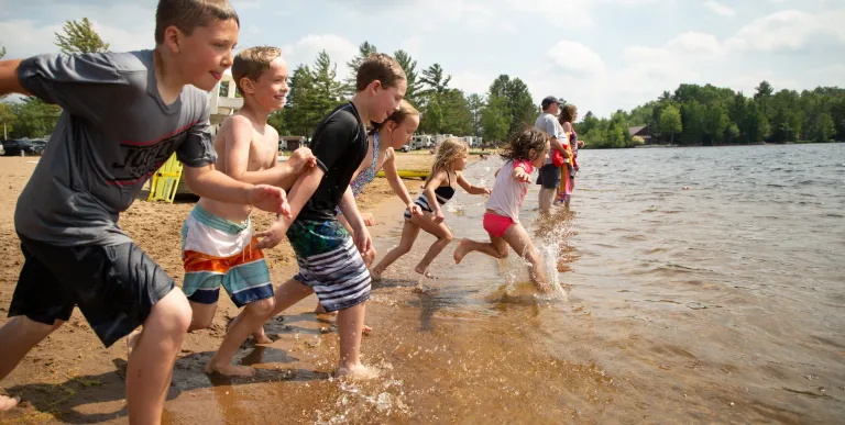 Young kids race into the water