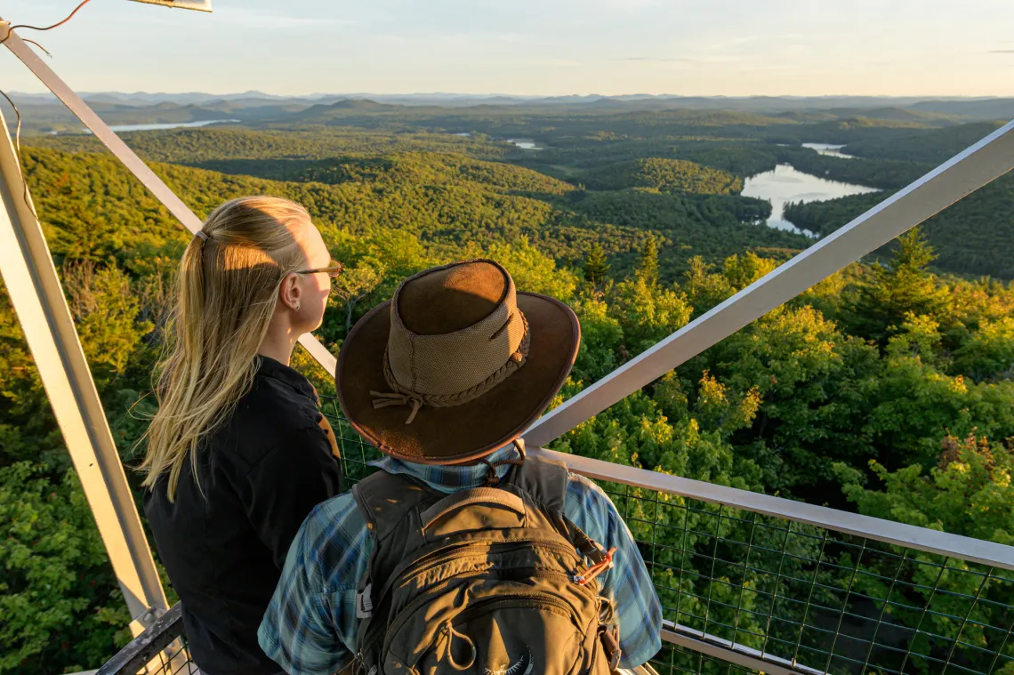 Two people watching the sunset from a firetower