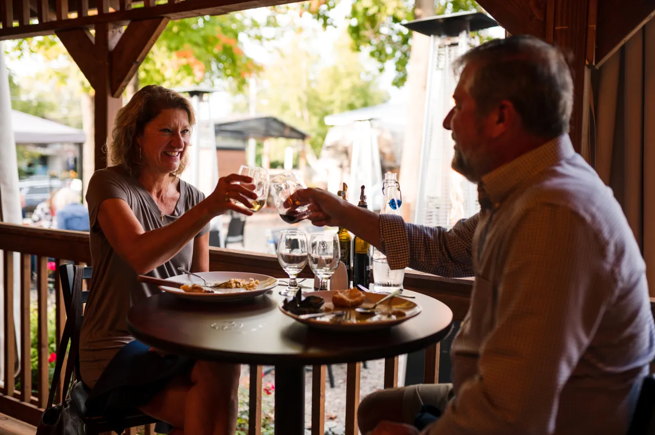A couple dining on a patio in Tupper Lake.