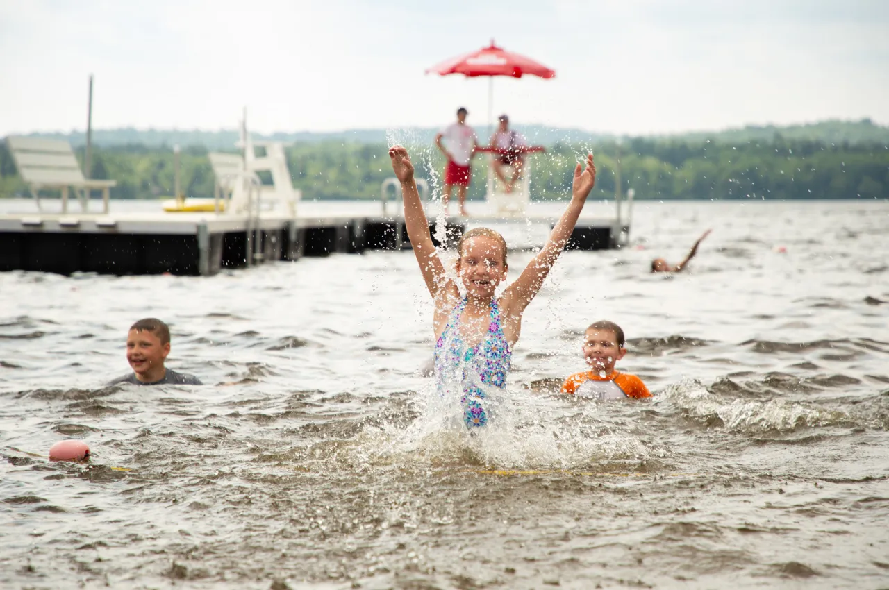 A group of children swimming at Little Wolf Beach.