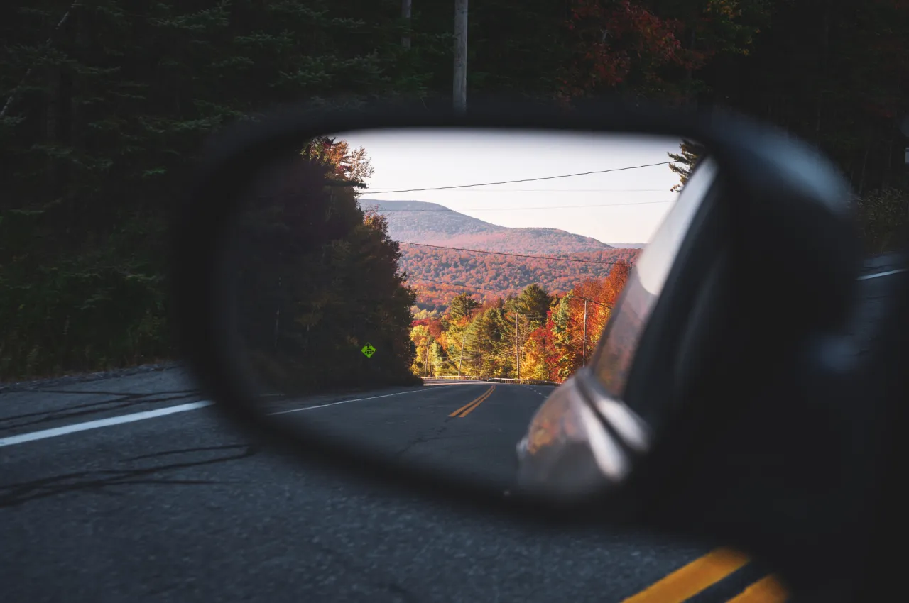 Fall views from a car's rearview mirror.