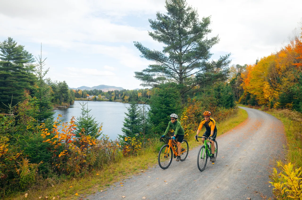 Two bikers on the Adirondack Rail Trail in the fall.