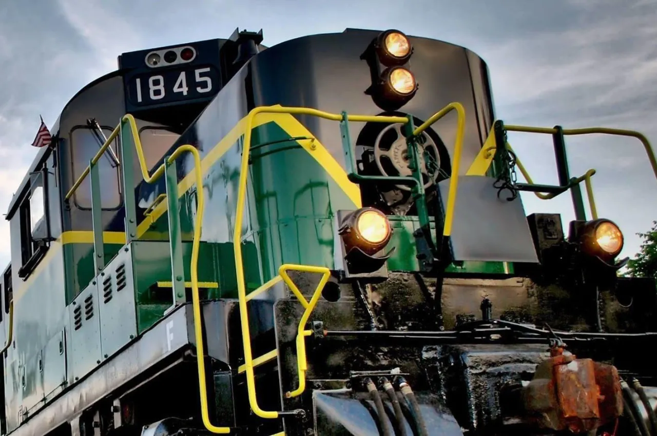 A close up of the front of a green and yellow train. 