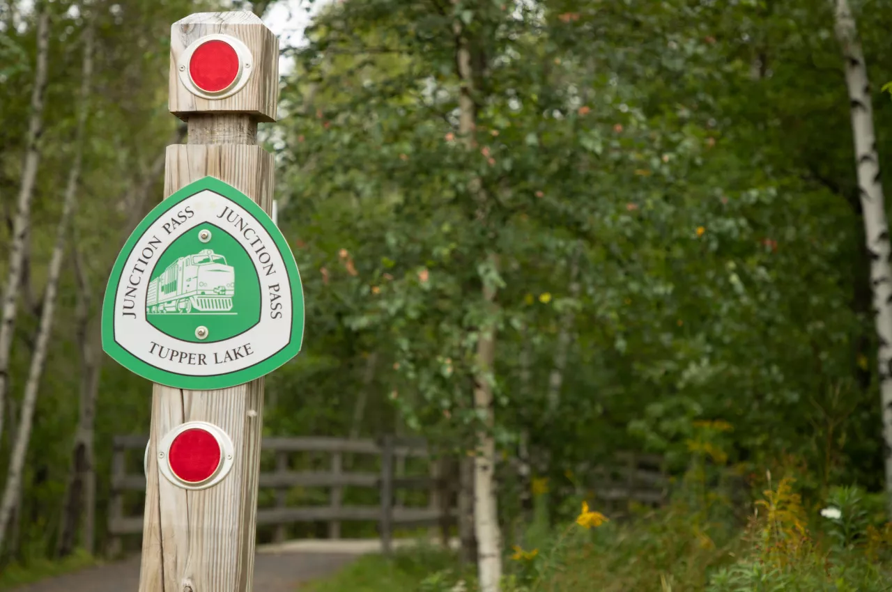 A wooden post displaying a Junction Pass Trail sign