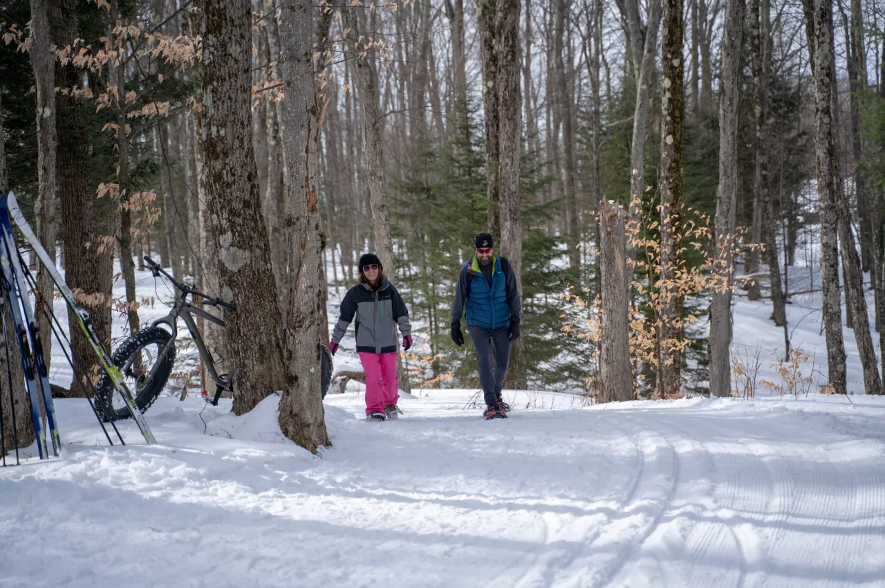 A couple walks the trails with snowshoes at the James C. Frenette Sr. Recreation Trails 