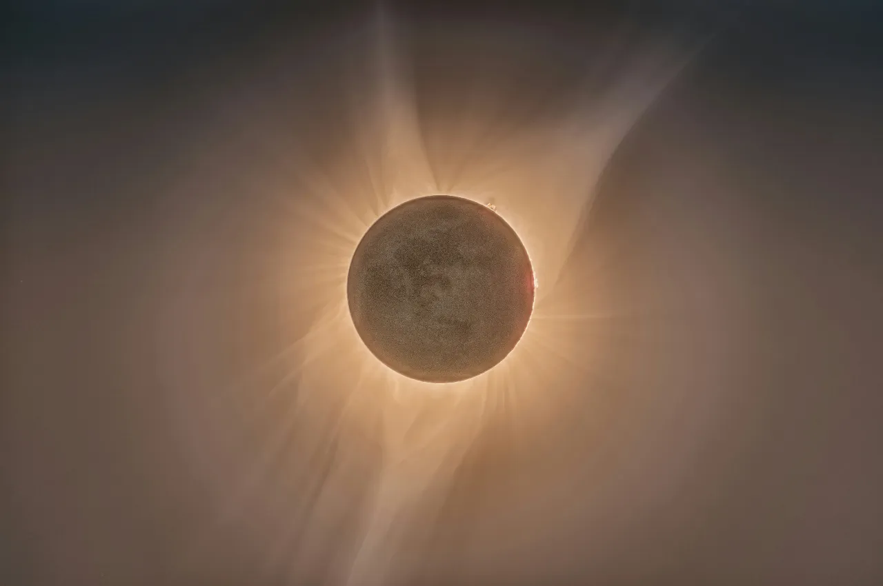 A high-quality close-up image of the Earth's moon blocking the sun in a total solar eclipse, with streams of corona visible.