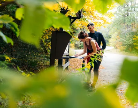 A couple signing into the Goodman Mountain trailhead register