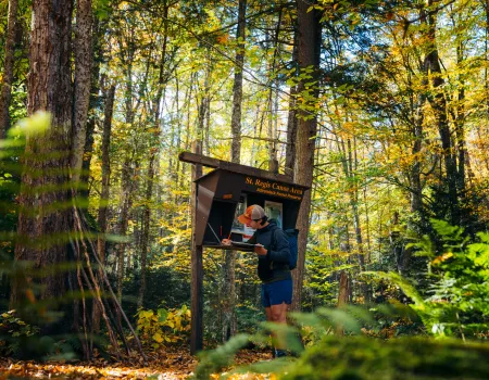 A hiker signing into the register for a mountain