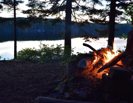 A campfire at the edge of the water