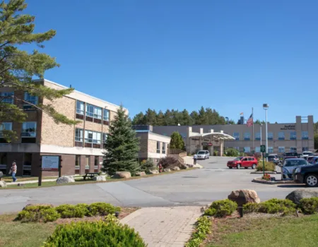 The big brick building and parking area of Adirondack Health Saranac Lake.