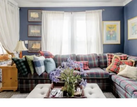 The formal sitting area with large window and plaid sectional couch