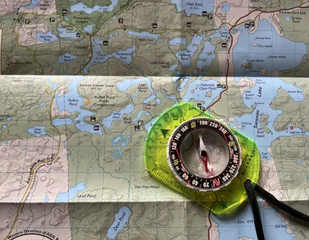 A map with a compass laying on top.