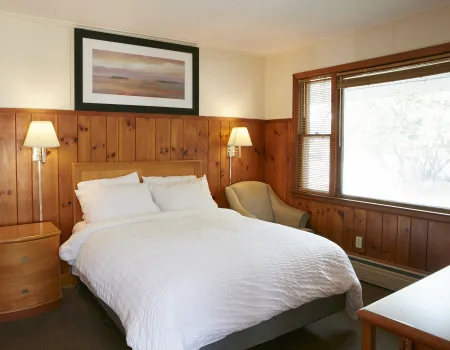 Plush white linens on a king bed at The Ashley.