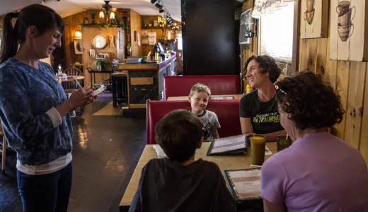A family sits in a booth with menus.