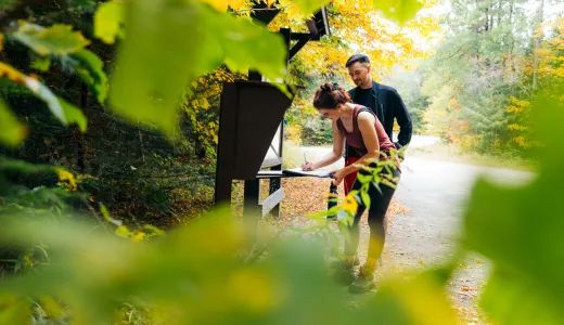 A couple signing into the Goodman Mountain trailhead register