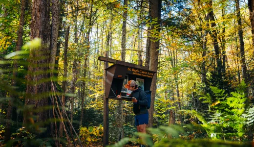 A hiker signing into the register for a mountain