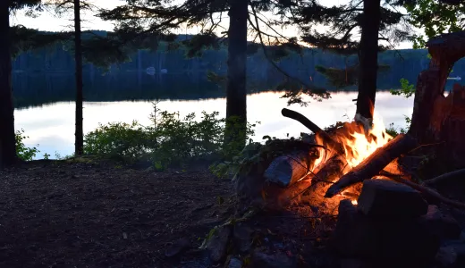 A campfire at the edge of the water