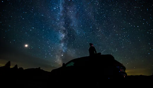 A person on their car stargazing