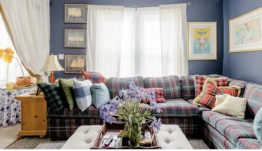 The formal sitting area with large window and plaid sectional couch