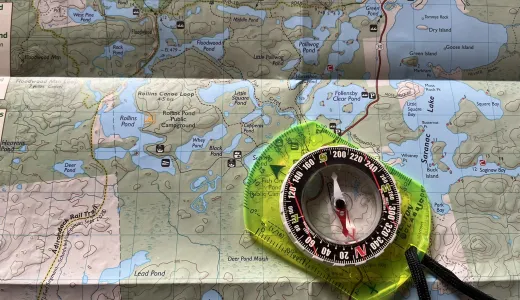 A map with a compass laying on top.