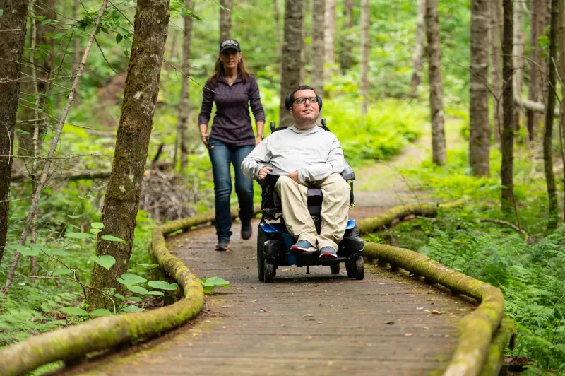 man in wheelchair on boardwalk in john dillon park