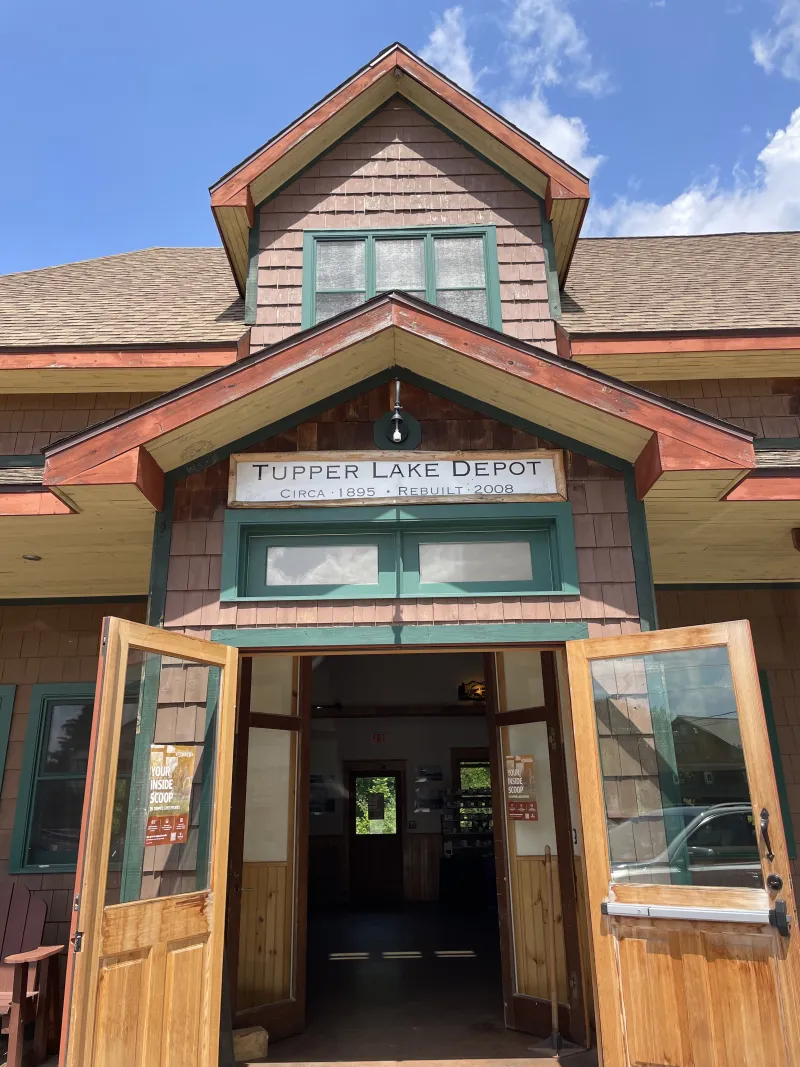 The entrance to the renovated Tupper Lake depot, with a blue sky and white clouds above