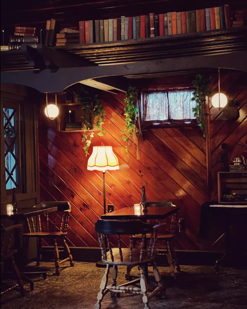 rustic two seat dining with a hidden bookshelf in the ceiling.