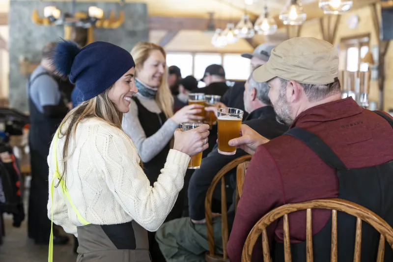 A group of people drinking pints of beer at a brewery