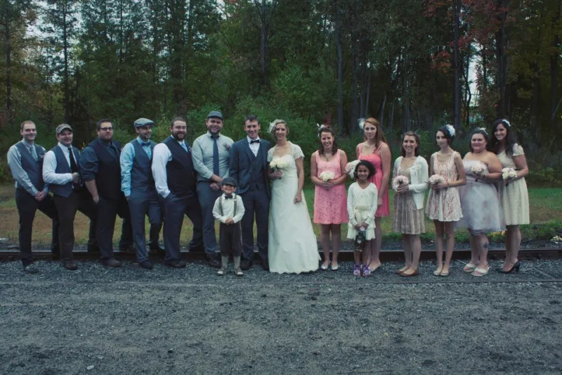 Faith & Andrew share a moment with their wedding party outside of the Tupper Lake Train Depot (Emily Lauren Photography)