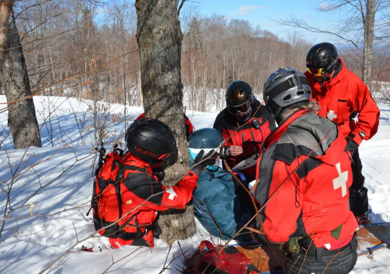 A team of Mitch Harriman, Anne Maltais, Adam Hurteau, and Dan King work together on training scenario two in the woods off of the Lift Line trail.