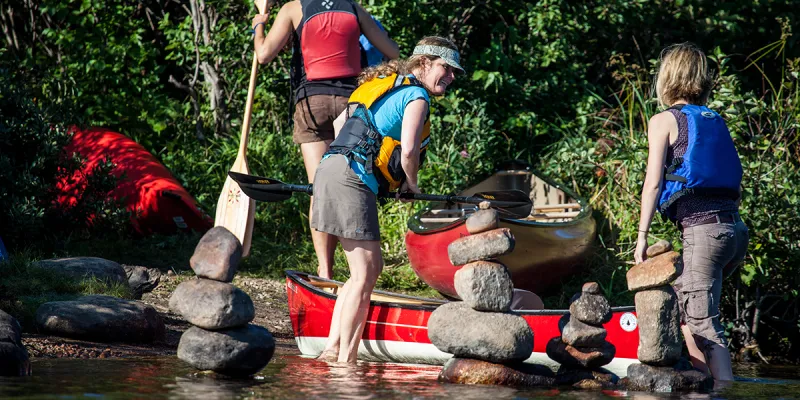Anne Fleck from Raquette River Outfitters helps load a canoe into Simon Pond.