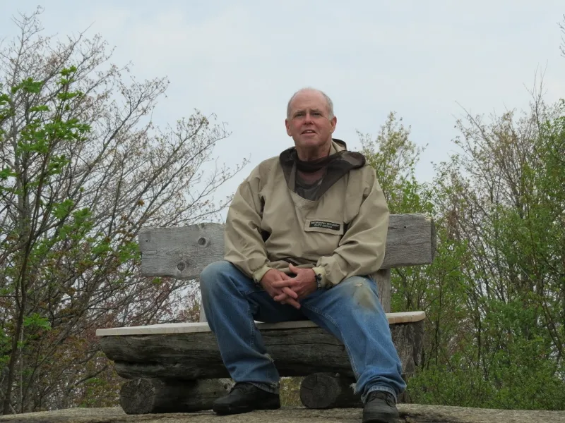 Thomas Cullen relaxing on a wooden bench at an overlook on Mount Arab