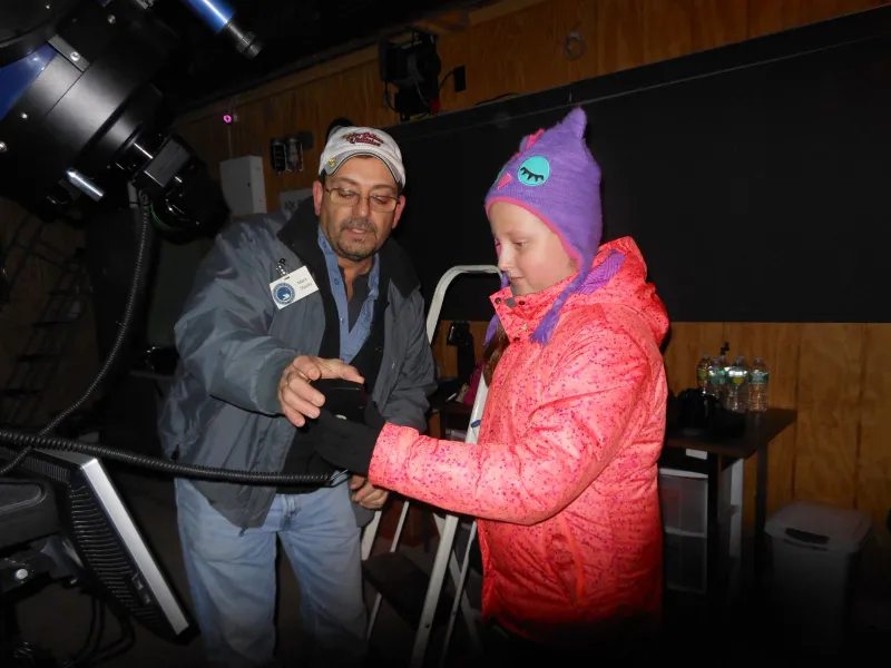 Marc showing Genna how to use the telescope