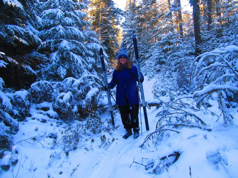Trisa Minton removes her skis for a downed tree