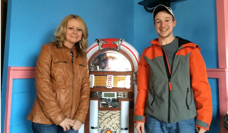 Amanda & Mike Kelly pose next to the 50's style jukebox at "under construction" Ohana's 50's Diner