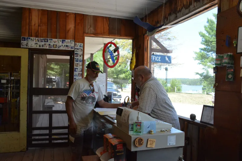 Frank Scotti points out a point of interest to a local visitor in the Blue Jay Campsite office.