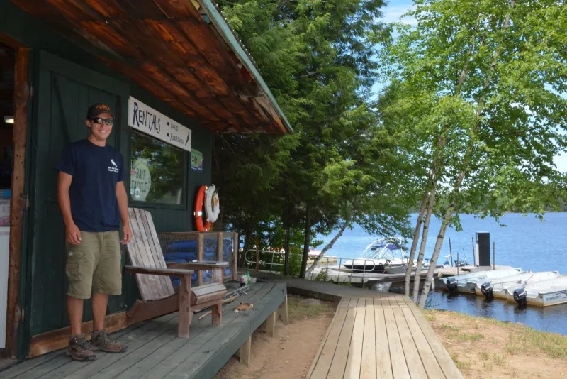 Mitch Harriman, a Blue Jay Campsite employee, stands in front of the marina's boathouse before heading down to the dock to help customers.
