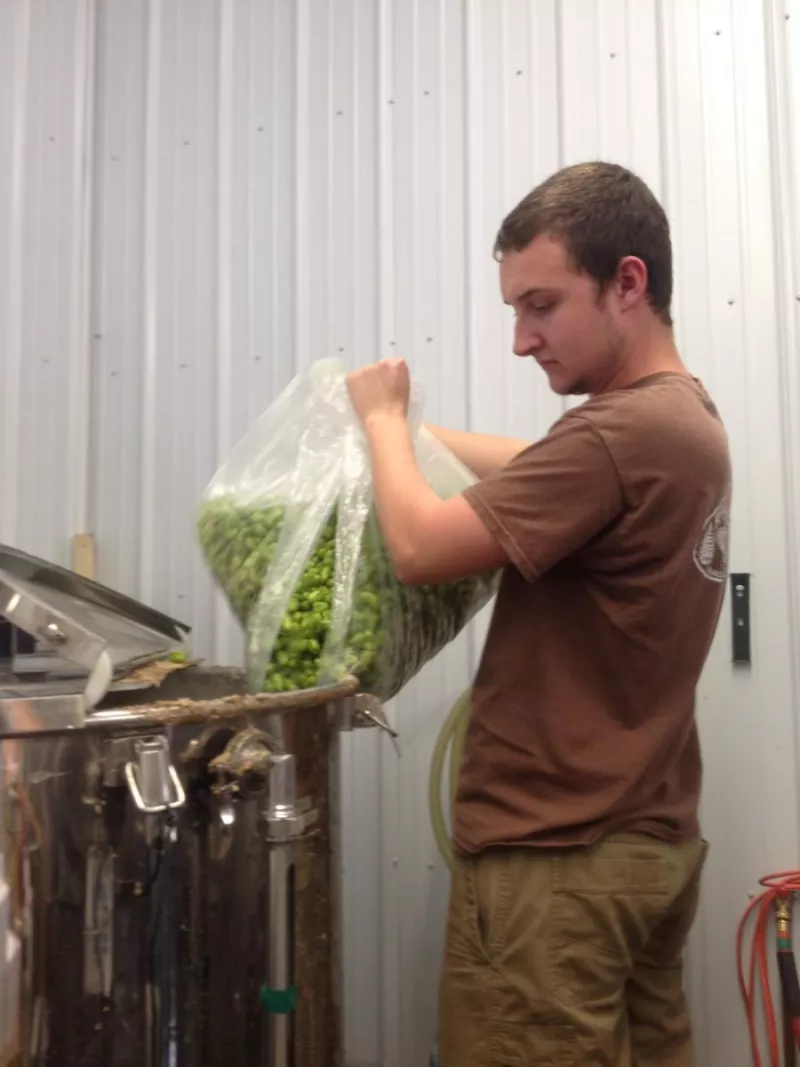 Alexander pouring in the haul of local hops.