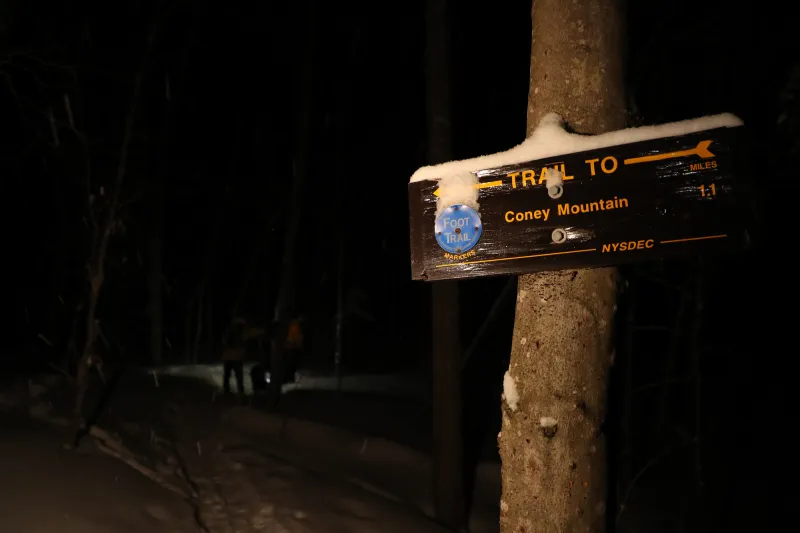 The trail sign to Coney Mountain shines in the darkness.