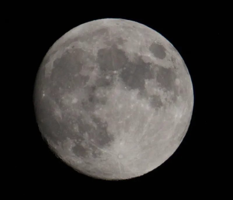 Close-up view of a full moon with dark sky beyond.