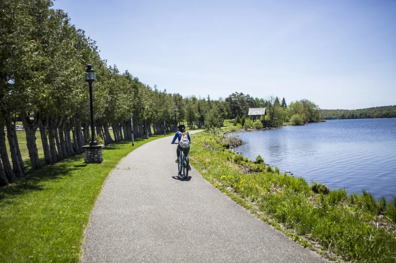 A solo cyclist glides along the waterfront paved path.