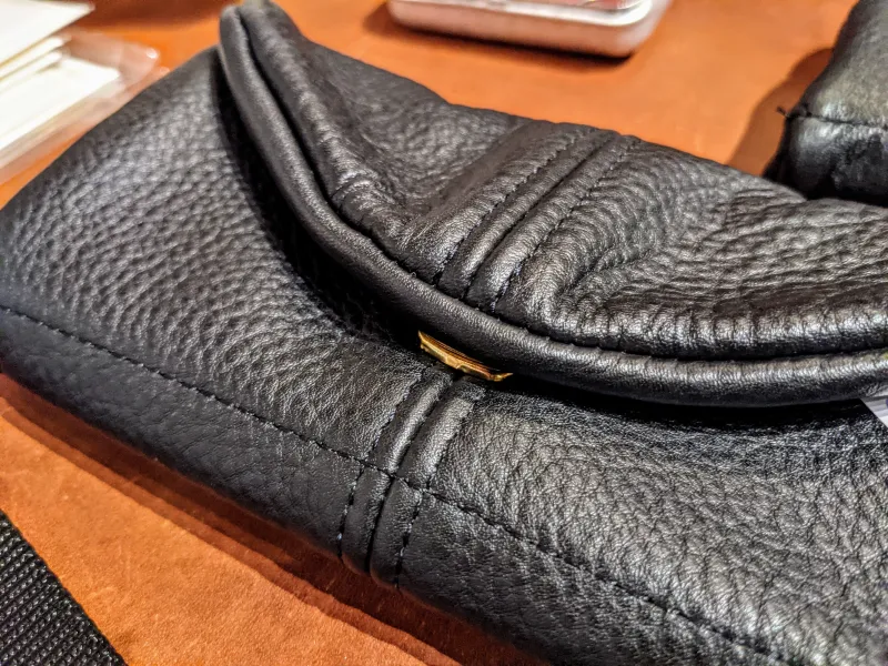 Close up of a black leather wallet with golden clasp.
