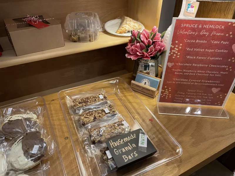 A store display of homemade baked goods on wooden shelves.