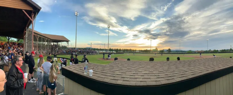 A fan's view watching an active baseball game with a crowd watching.