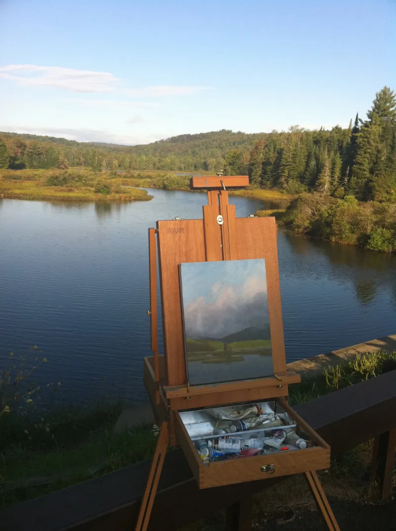 A painting in front of an outdoor landscape