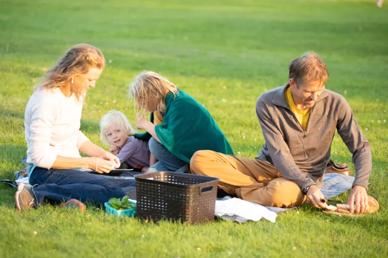 Family enjoying food at a picnic.